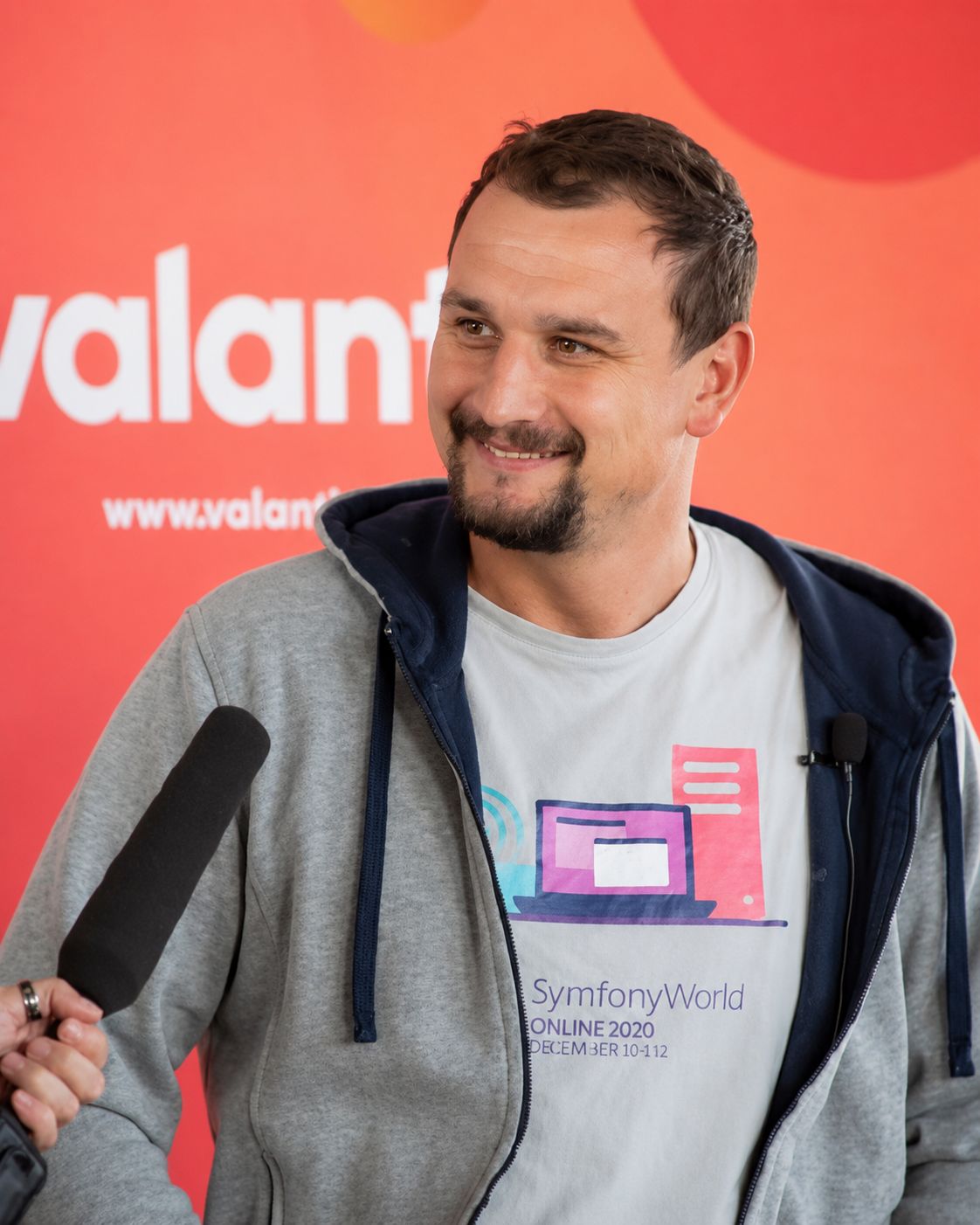 Rafał Wesołowski im Interview, mit einem Mikrofon in der Hand.